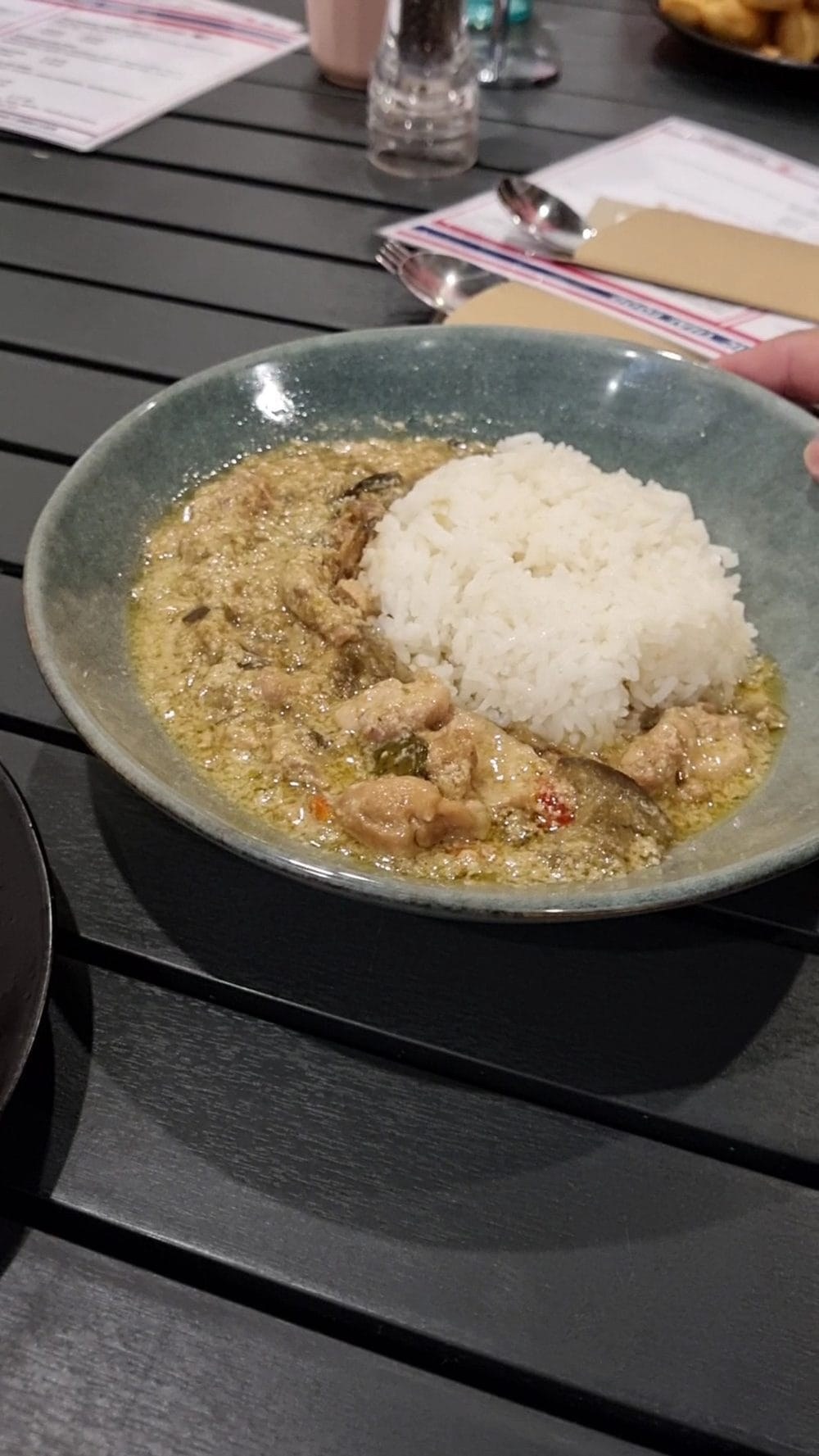 A rich Thai curry served with steamed rice on the dark timber tables at Rim Thang Thai, Glenelg