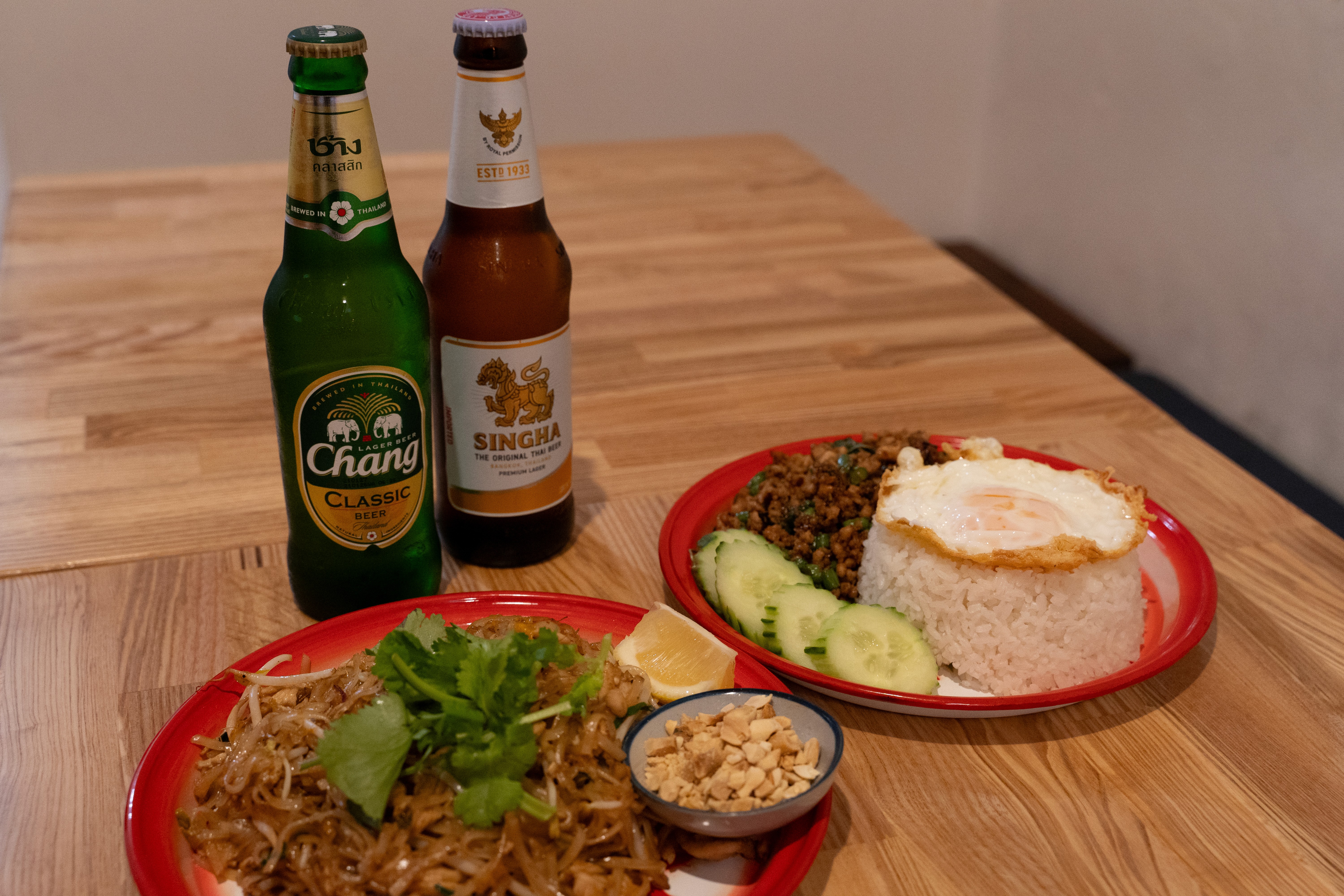 Thai noodle dishes served with Chang and Singha beers at Rim Thang Thai in Glenelg — the classic drunken noodles pairing